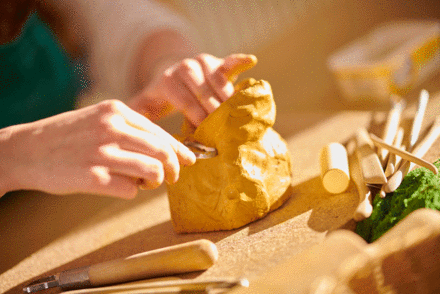 Hände formen einen Tonklumpen